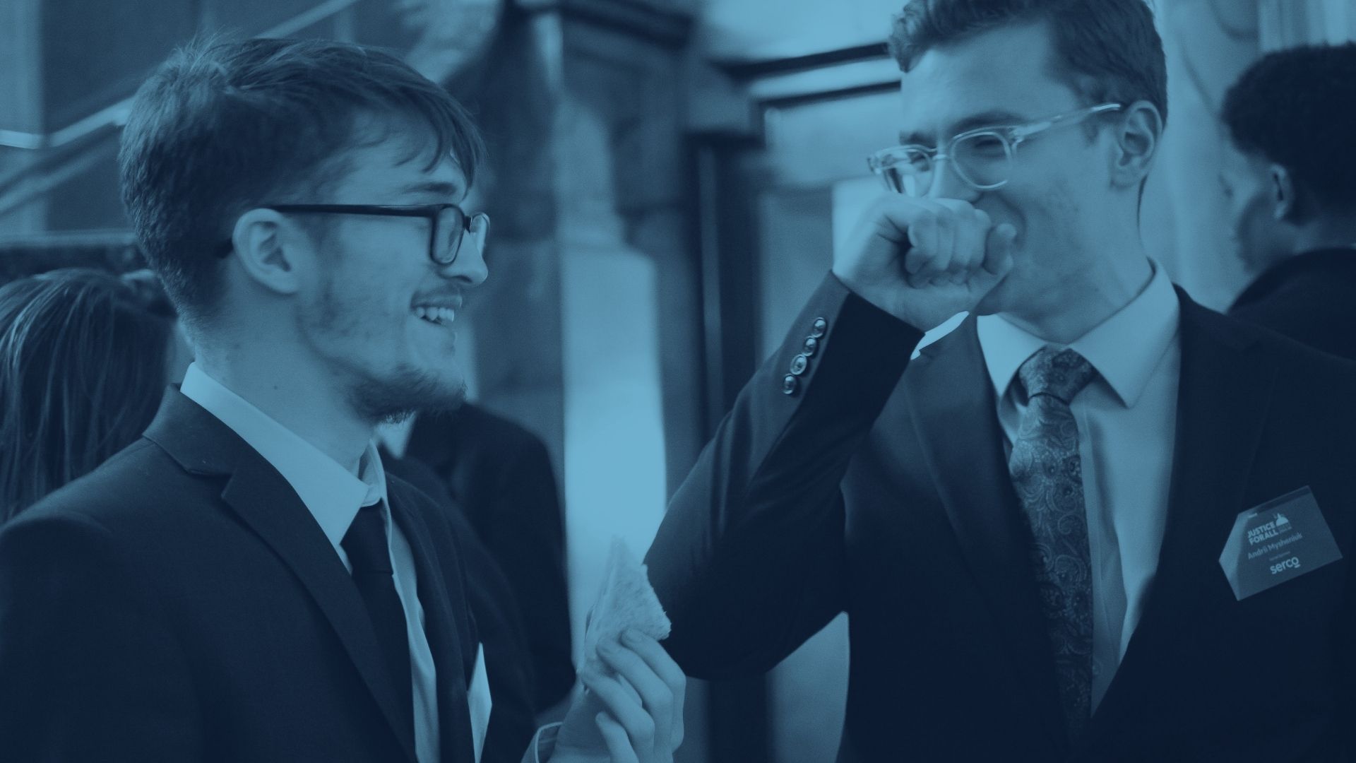 Two young professionals talking together at a business networking event